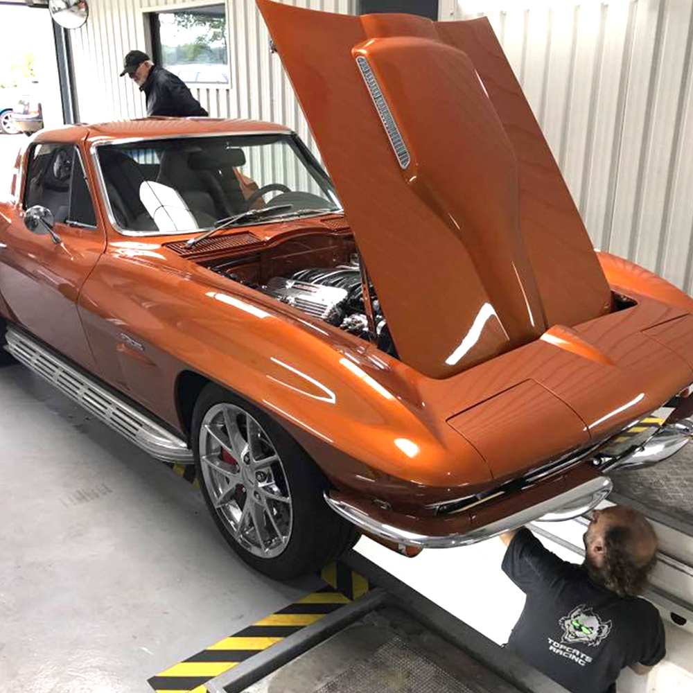 topcats racing team working on copper 1965 corvette stingray with bonnet open
