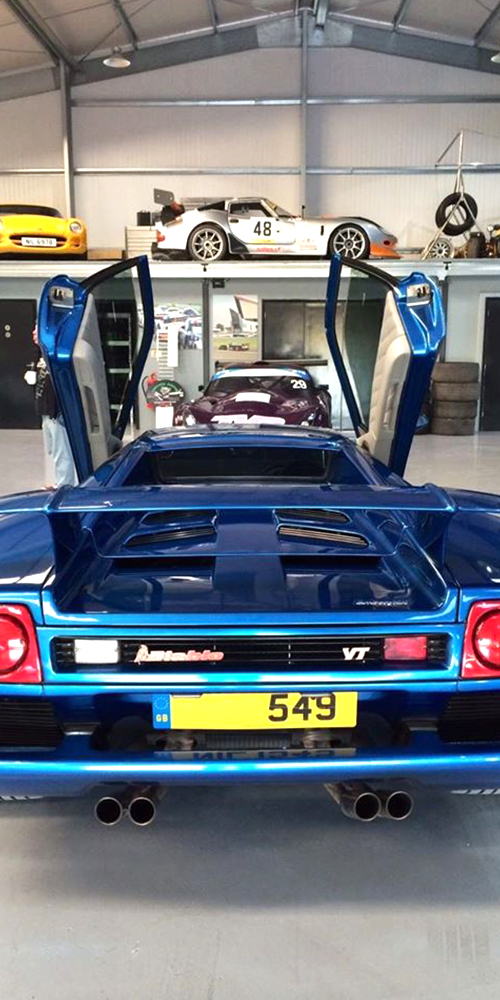 photo of electric blue rear bumper of lamborghini diablo with scissor doors open on either side