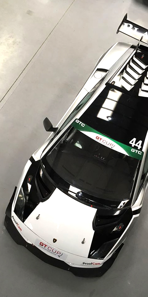 overhead view of white and black lamborghini gallardo in topcats racing workshop