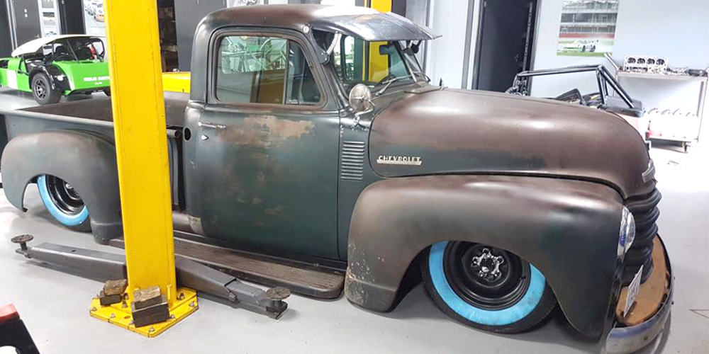 rusted 1950s chevrolet pickup being inspected and repaired at topcats racing workshop