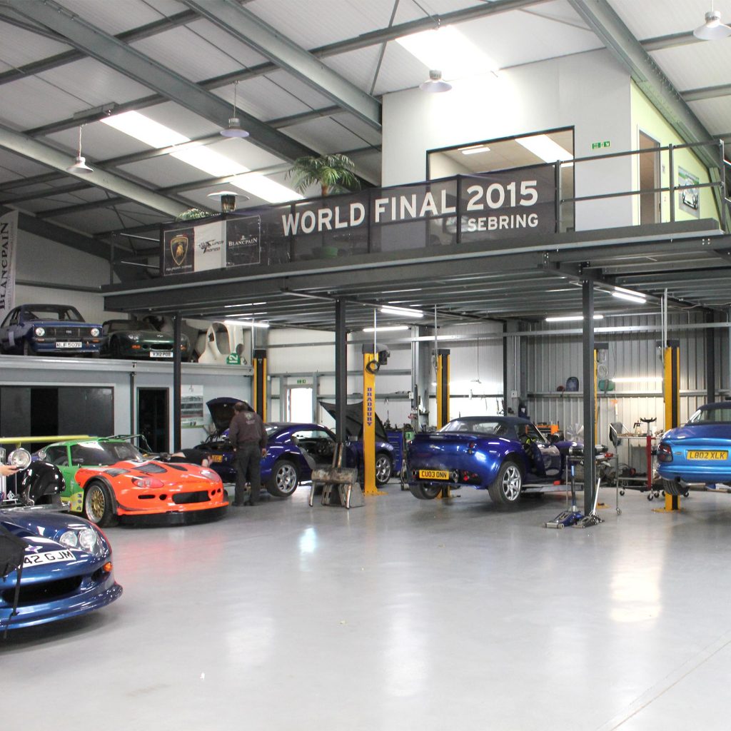 topcats racing workshop with variety of cars on ramp and overlooking balcony in distance