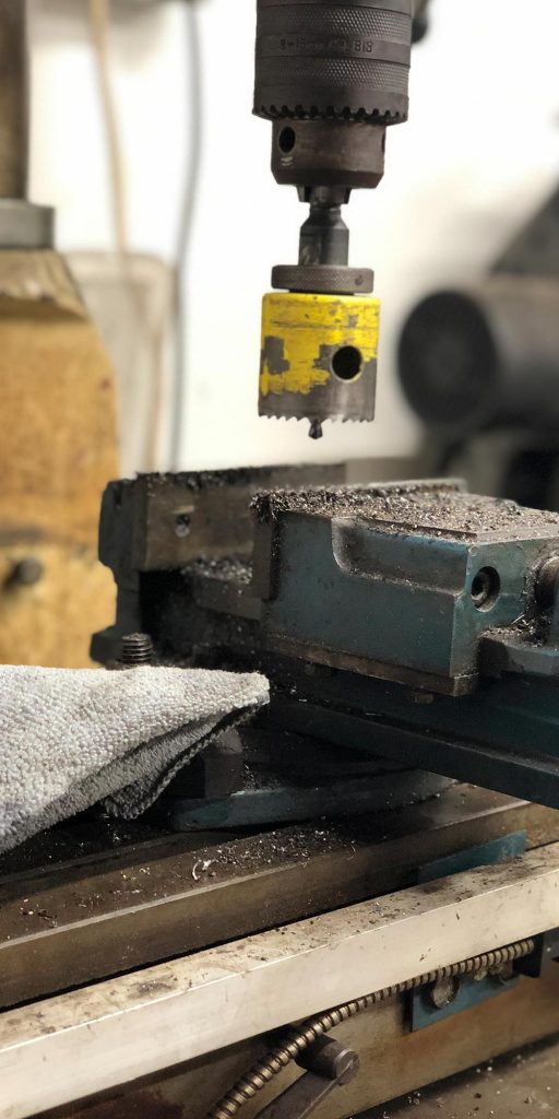 close up of hole saw on pillar drill at topcats racing workshop